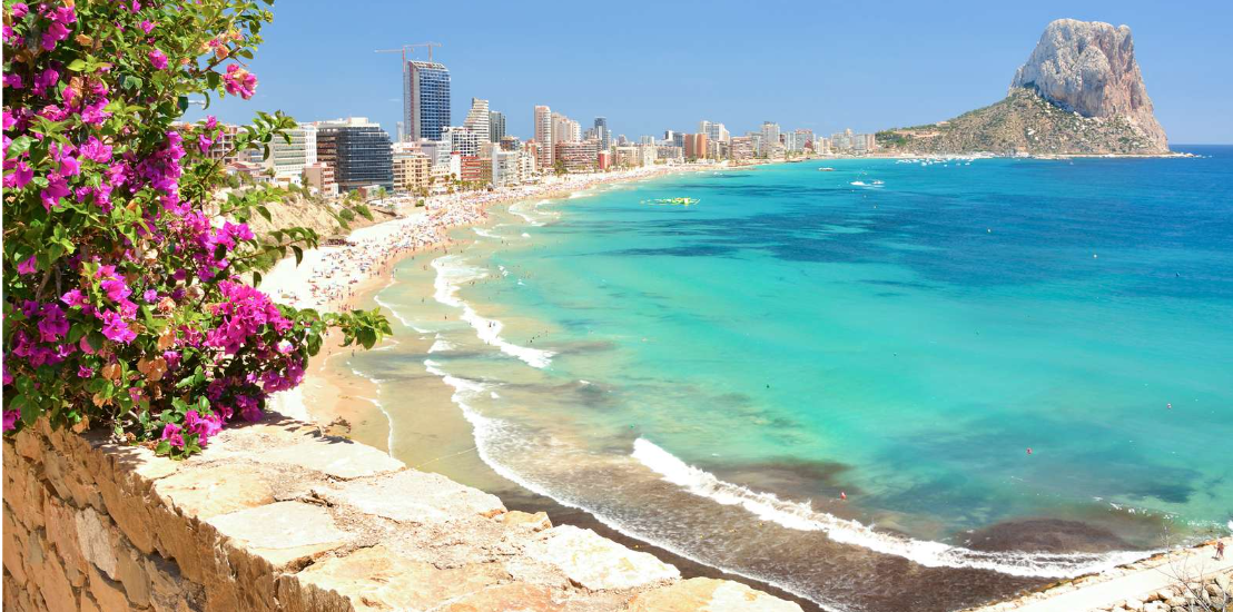 Boats anchored in crystal clear turquoise waters of Costa Blanca